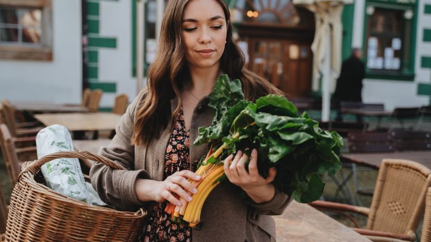 Young woman with a basket shopping for fresh vegetables outdoors in Erfurt, Germany.